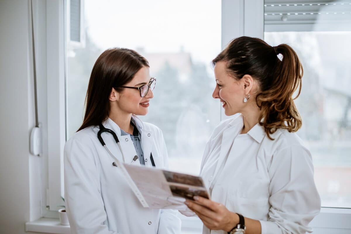 Two female doctors discussing about the reports